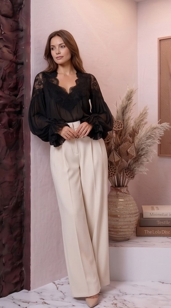 blusa de estilo bohemio romántico en dos colores: blanco y negro. La blusa destaca por su escote en V profundo con encaje floral detallado y sus mangas largas abullonadas con puños con volantes plisados.