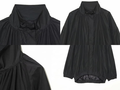 Detalle del dobladillo, costuras y acabado de Chaqueta estilo bomber negra de corte oversized con cuello alto alzado, cierre de cremallera frontal y mangas largas abullonadas con puños elásticos, fabricada en tejido ligero de poliéster para un look urbano y casual.