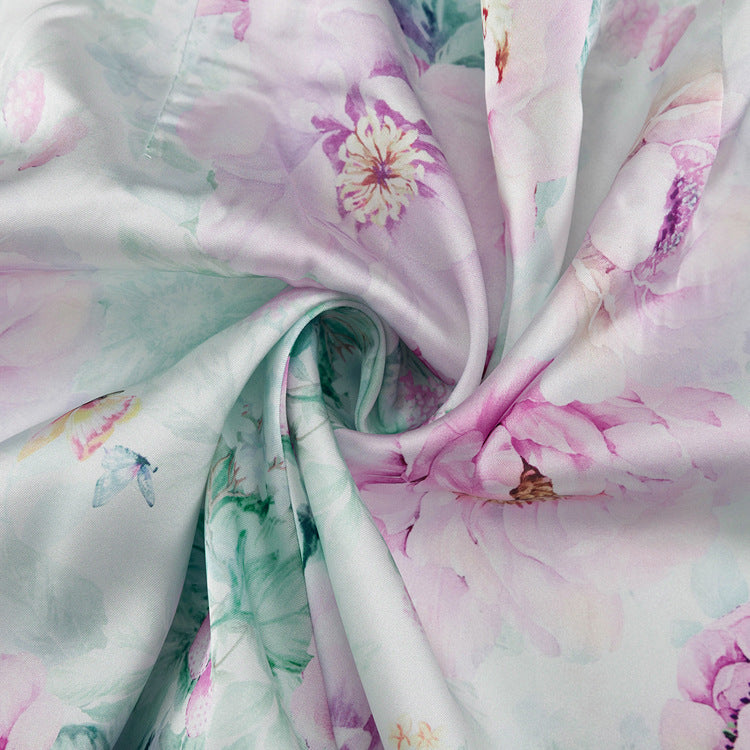 Detalle del dobladillo, costuras y acabado de conjunto de dos piezas floral en tonos rosa y pastel: blazer corto cropped de manga larga con solapas y botones frontales combinado con falda-pantalón mini de tiro alto a juego