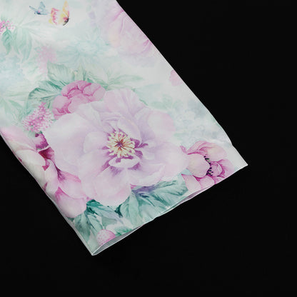 Detalle del dobladillo, costuras y acabado de conjunto de dos piezas floral en tonos rosa y pastel: blazer corto cropped de manga larga con solapas y botones frontales combinado con falda-pantalón mini de tiro alto a juego