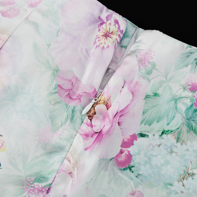Detalle del dobladillo, costuras y acabado de conjunto de dos piezas floral en tonos rosa y pastel: blazer corto cropped de manga larga con solapas y botones frontales combinado con falda-pantalón mini de tiro alto a juego