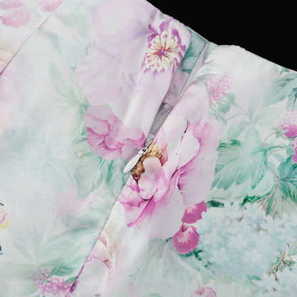 Detalle del dobladillo, costuras y acabado de conjunto de dos piezas floral en tonos rosa y pastel: blazer corto cropped de manga larga con solapas y botones frontales combinado con falda-pantalón mini de tiro alto a juego