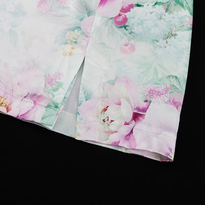 Detalle del dobladillo, costuras y acabado de conjunto de dos piezas floral en tonos rosa y pastel: blazer corto cropped de manga larga con solapas y botones frontales combinado con falda-pantalón mini de tiro alto a juego