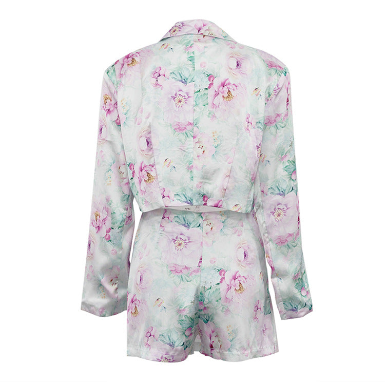 Detalle del dobladillo, costuras y acabado de conjunto de dos piezas floral en tonos rosa y pastel: blazer corto cropped de manga larga con solapas y botones frontales combinado con falda-pantalón mini de tiro alto a juego