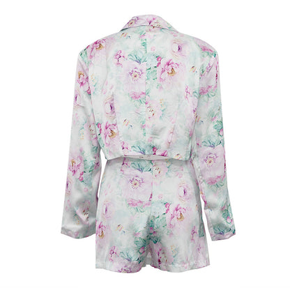 Detalle del dobladillo, costuras y acabado de conjunto de dos piezas floral en tonos rosa y pastel: blazer corto cropped de manga larga con solapas y botones frontales combinado con falda-pantalón mini de tiro alto a juego