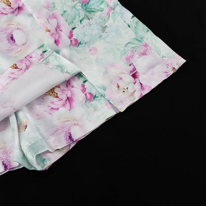 Detalle del dobladillo, costuras y acabado de conjunto de dos piezas floral en tonos rosa y pastel: blazer corto cropped de manga larga con solapas y botones frontales combinado con falda-pantalón mini de tiro alto a juego