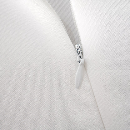 Detalle del dobladillo, costuras y acabado de Vestido corto entallado de manga larga en color liso con cuello subido y falda de línea A, detalle de abertura en la espalda con botones de perla y cierre de cremallera.