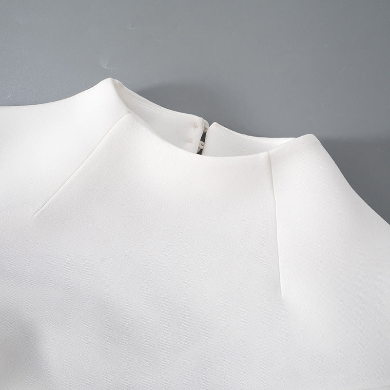 Detalle del dobladillo, costuras y acabado de Vestido corto entallado de manga larga en color liso con cuello subido y falda de línea A, detalle de abertura en la espalda con botones de perla y cierre de cremallera.