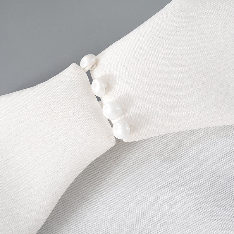 Detalle del dobladillo, costuras y acabado de Vestido corto entallado de manga larga en color liso con cuello subido y falda de línea A, detalle de abertura en la espalda con botones de perla y cierre de cremallera.