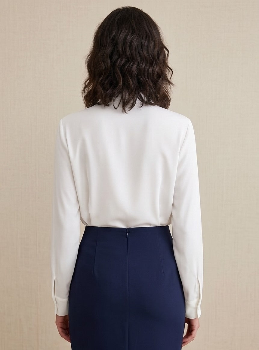 Blusa blanca de manga larga para mujer con solapa asimétrica cruzada, cuello camisero elegante y detalle de botón joya brillante.