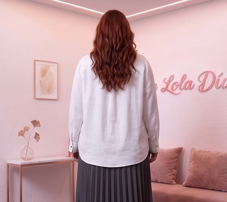 Blusa fluida de mujer en color blanco con cuello camisero abierto en V, diseño frontal cruzado drapeado, manga larga holgada con puño de botón y corte suelto con bajo asimétrico