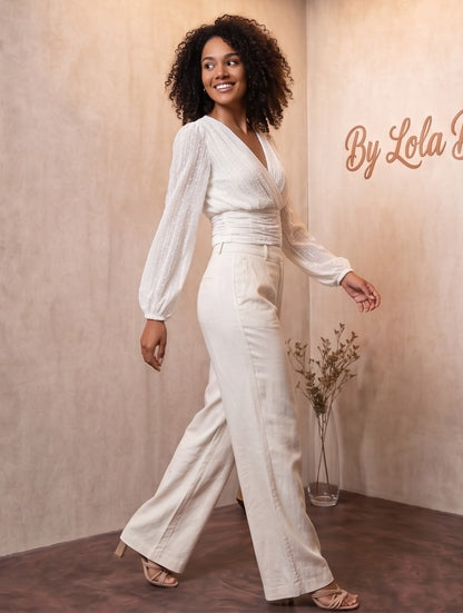 elegante blusa blanca de plumeti con escote en V cruzado, cintura drapeada y mangas largas abullonadas