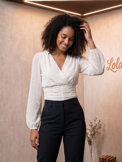 elegante blusa blanca de plumeti con escote en V cruzado, cintura drapeada y mangas largas abullonadas