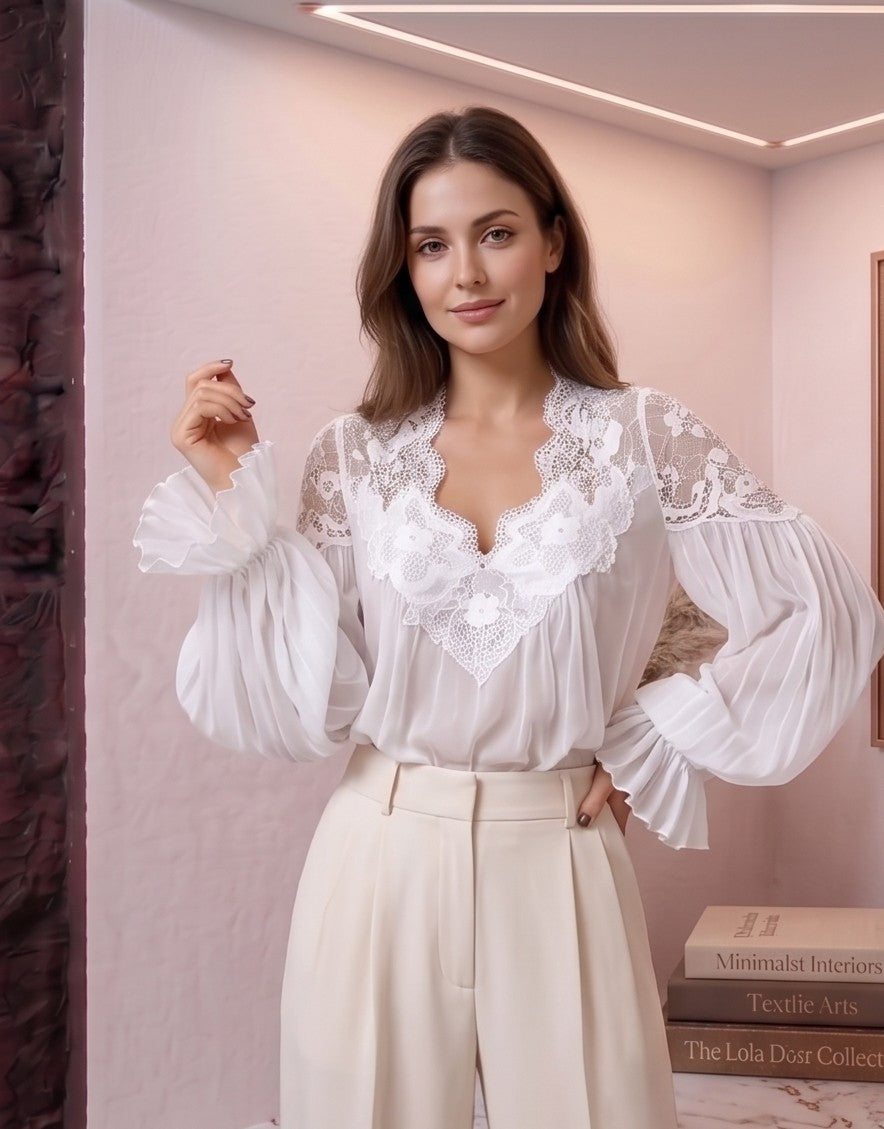 blusa de estilo bohemio romántico en dos colores: blanco y negro. La blusa destaca por su escote en V profundo con encaje floral detallado y sus mangas largas abullonadas con puños con volantes plisados.