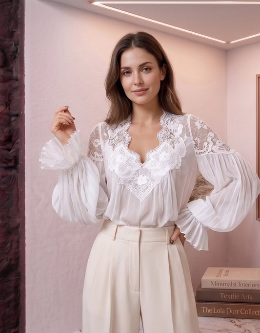 blusa de estilo bohemio romántico en dos colores: blanco y negro. La blusa destaca por su escote en V profundo con encaje floral detallado y sus mangas largas abullonadas con puños con volantes plisados.