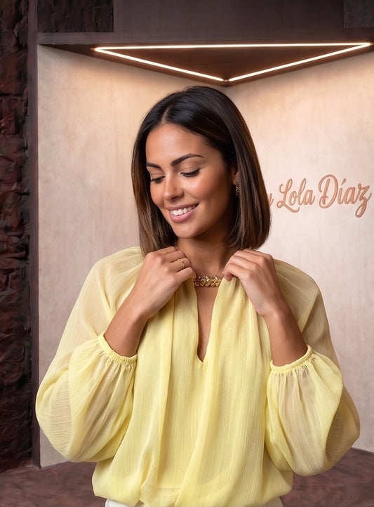 blusa fluida de gasa en tono amarillo pastel con escote en V fruncido, mangas largas abullonadas y detalle en la espalda