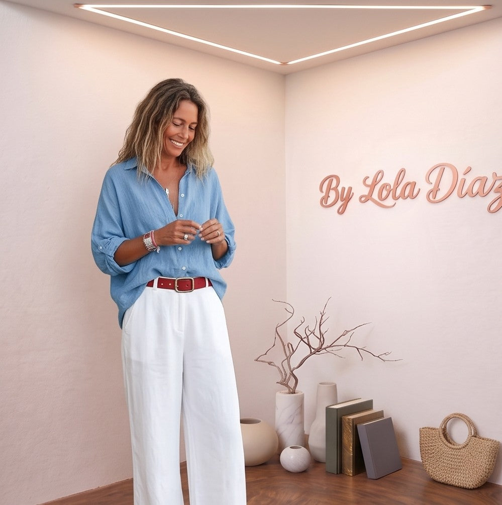 blusa de lino rosa pastel de manga corta fruncida y escote en V, combinada con pantalones blancos de talle alto. La blusa es fluida y fresca