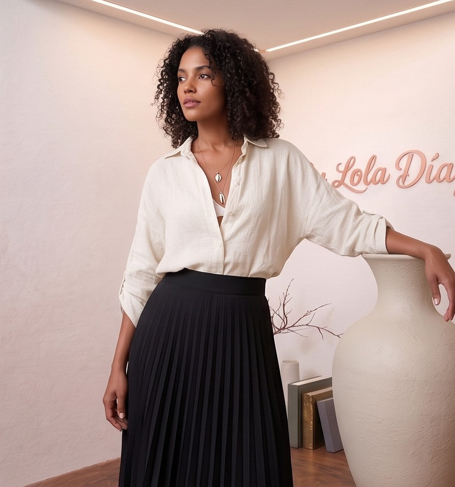 blusa de lino rosa pastel de manga corta fruncida y escote en V, combinada con pantalones blancos de talle alto. La blusa es fluida y fresca