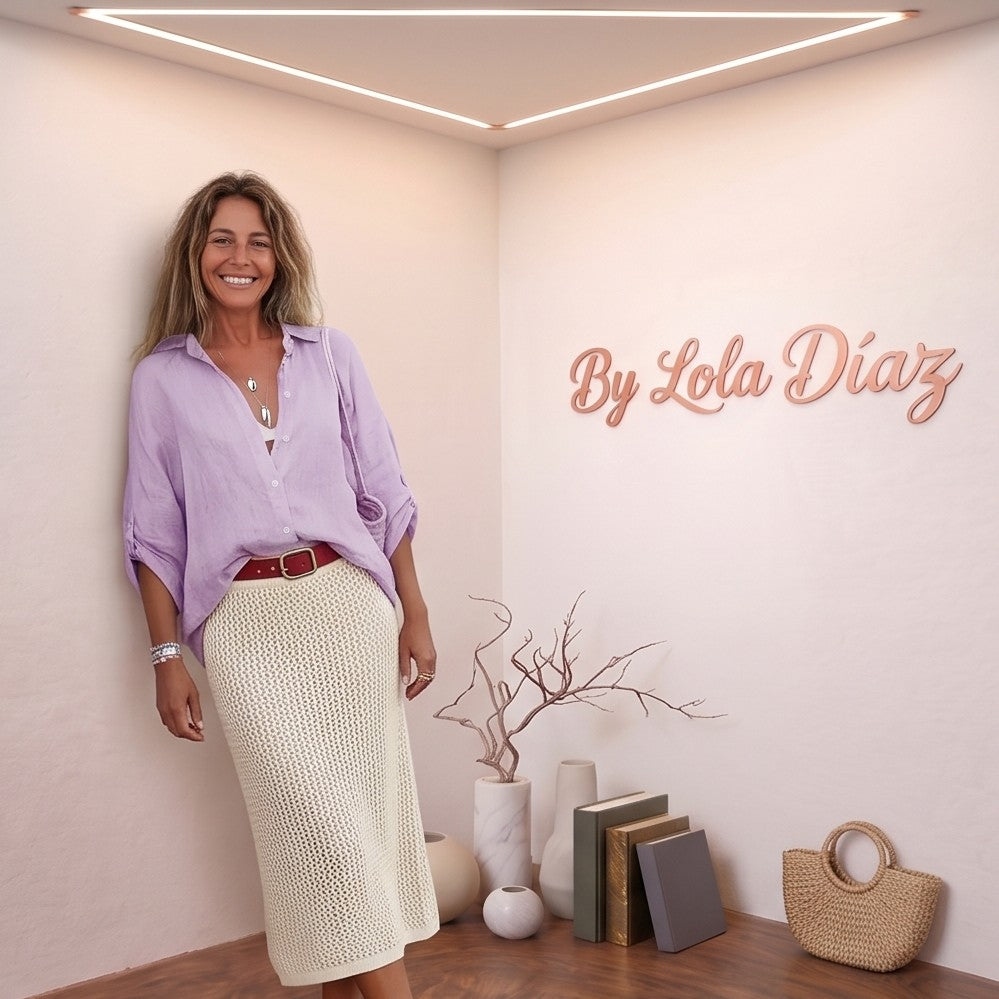 blusa de lino rosa pastel de manga corta fruncida y escote en V, combinada con pantalones blancos de talle alto. La blusa es fluida y fresca