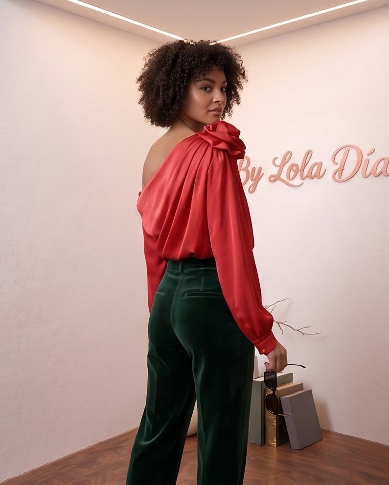 Blusa satinada de corte asimétrico con detalle de flor en relieve en el hombro, escote drapeado y manga larga abullonada disponible en varios colores