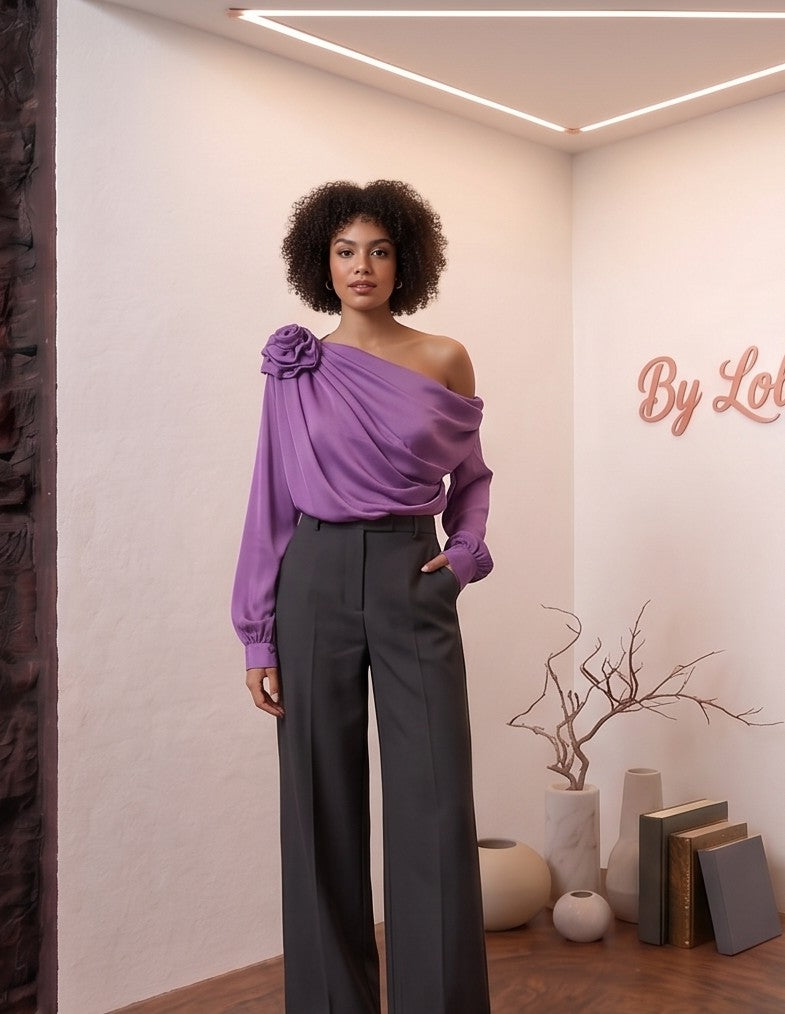 Blusa satinada de corte asimétrico con detalle de flor en relieve en el hombro, escote drapeado y manga larga abullonada disponible en varios colores