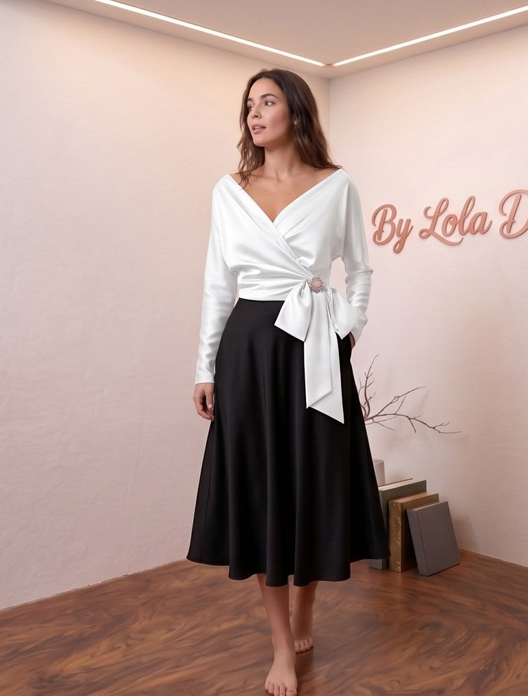 Blusa de satén de seda con diseño cruzado, escote en V y lazada lateral con detalle de broche. Disponible en varios colores: amarillo vibrante, azul cielo, blanco roto y champán. Manga larga y corte elegante y sofisticado.