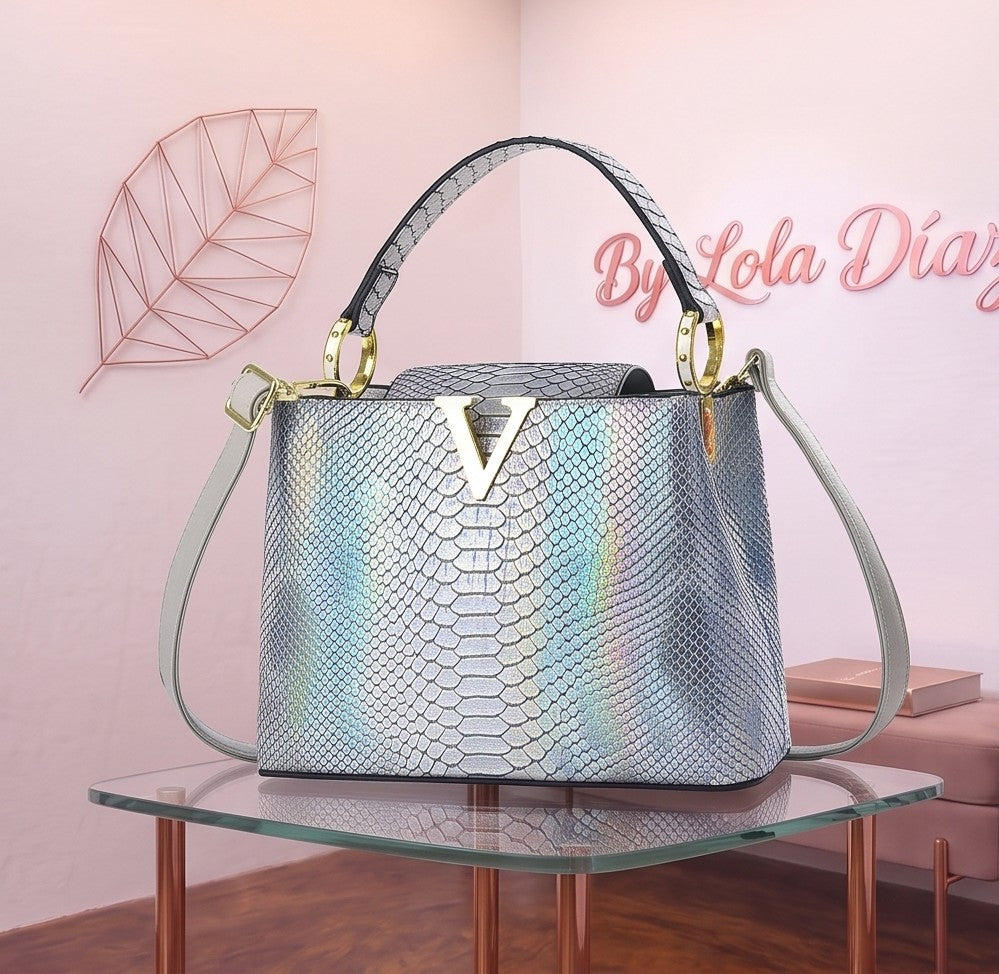 Bolso de mano y bandolera para mujer en material PU con acabado texturizado efecto piel de reptil cocodrilo y serpiente, herraje frontal dorado metálico en forma de V, asa superior rígida y correa ajustable para hombro; disponible en 9 colores: blanco puro, negro, caqui, café, blanco crema, morado, rosa, plateado y rojo oscuro; medidas compactas de 22x9x16 cm.