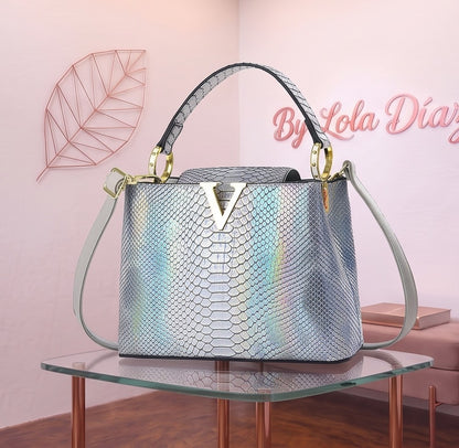 Bolso de mano y bandolera para mujer en material PU con acabado texturizado efecto piel de reptil cocodrilo y serpiente, herraje frontal dorado metálico en forma de V, asa superior rígida y correa ajustable para hombro; disponible en 9 colores: blanco puro, negro, caqui, café, blanco crema, morado, rosa, plateado y rojo oscuro; medidas compactas de 22x9x16 cm.