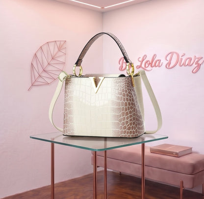 Bolso de mano y bandolera para mujer en material PU con acabado texturizado efecto piel de reptil cocodrilo y serpiente, herraje frontal dorado metálico en forma de V, asa superior rígida y correa ajustable para hombro; disponible en 9 colores: blanco puro, negro, caqui, café, blanco crema, morado, rosa, plateado y rojo oscuro; medidas compactas de 22x9x16 cm.