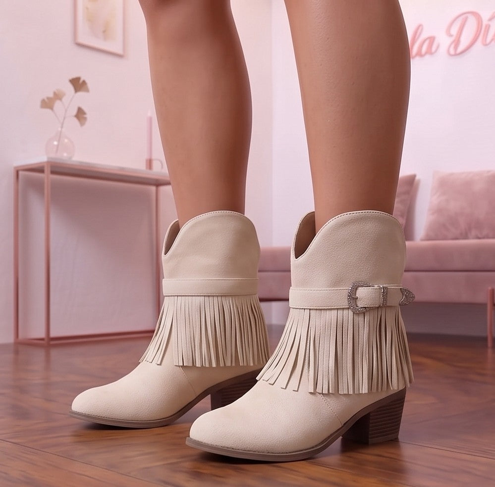 botas cowboy camperas para mujer de caña media con flecos decorativos y tira con hebilla grabada estilo western, confeccionadas en suave ante en cuatro tonos: blanco roto, marrón claro caramelo, negro clásico y rosa pastel, con tacón grueso cómodo y puntera redonda.