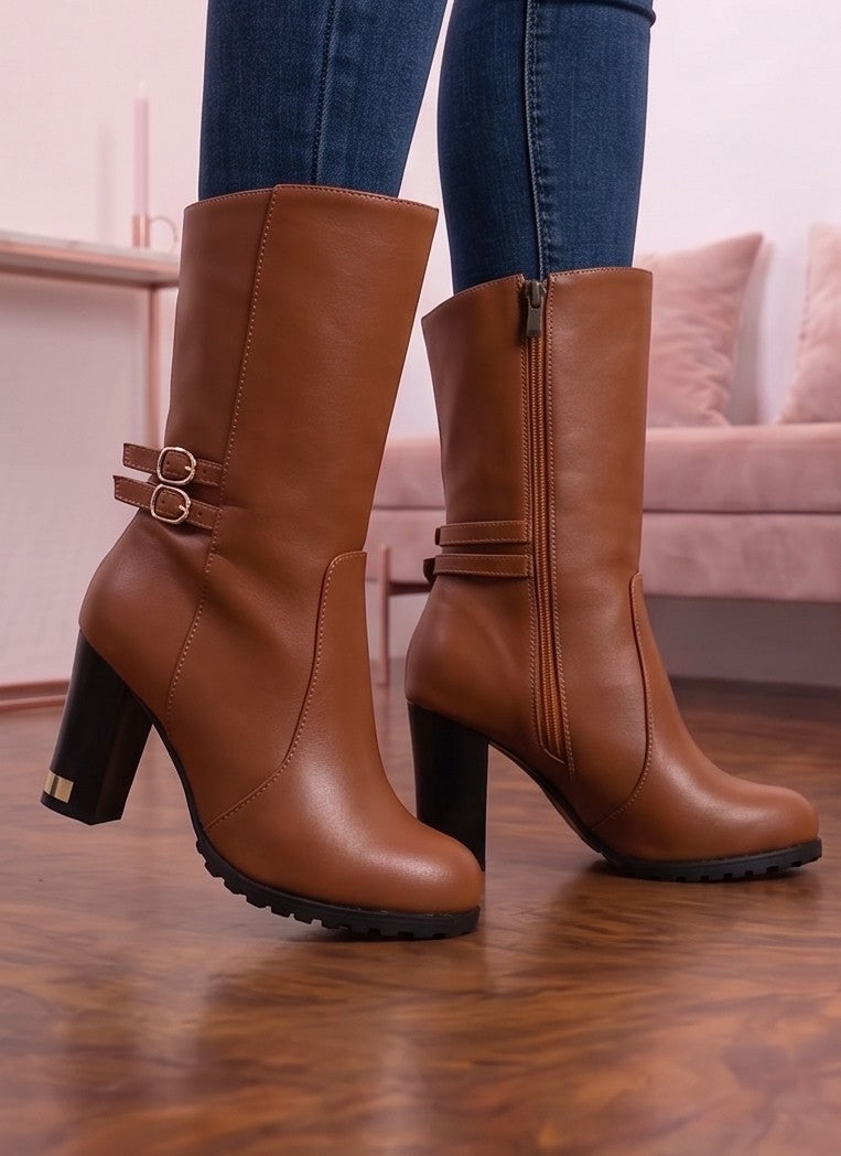 Botas de media caña para mujer en polipiel PU con tacón ancho alto y detalles metálicos dorados en la base del tacón. Diseño de puntera redonda con doble tira lateral decorativa, hebillas doradas redondas y cierre de cremallera interior. Disponibles en color negro, blanco y camel