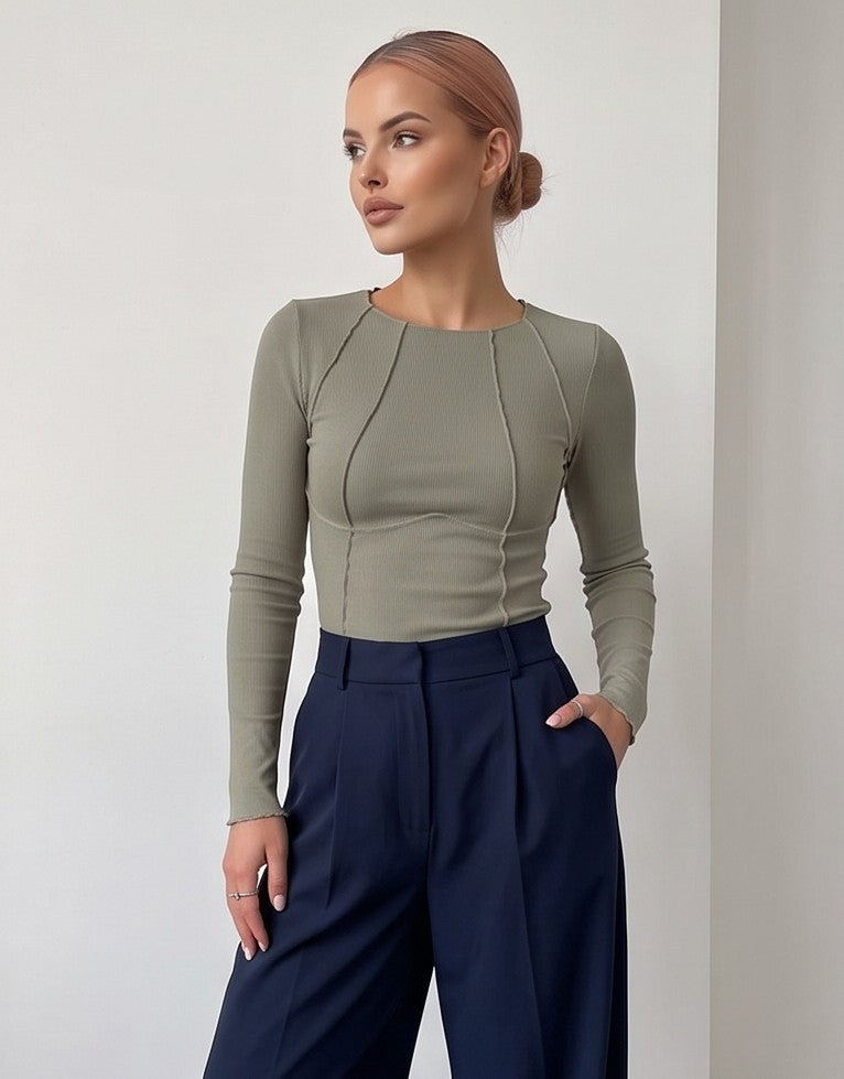 Camiseta ajustada de manga larga en tejido canalé fino con detalles de costuras vistas tipo corsé, disponible en blanco, negro, azul marino, verde oliva y rosa fucsia.