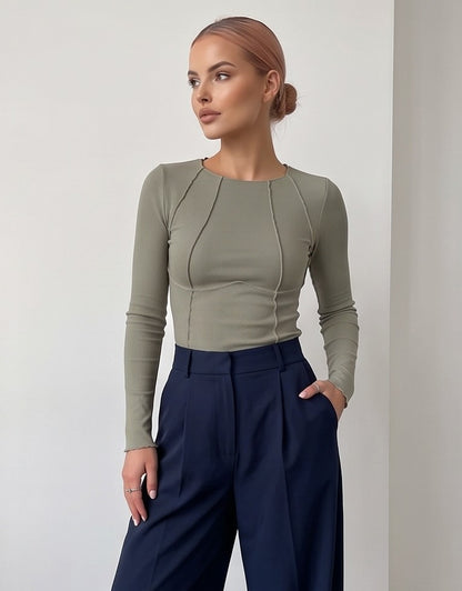 Camiseta ajustada de manga larga en tejido canalé fino con detalles de costuras vistas tipo corsé, disponible en blanco, negro, azul marino, verde oliva y rosa fucsia.