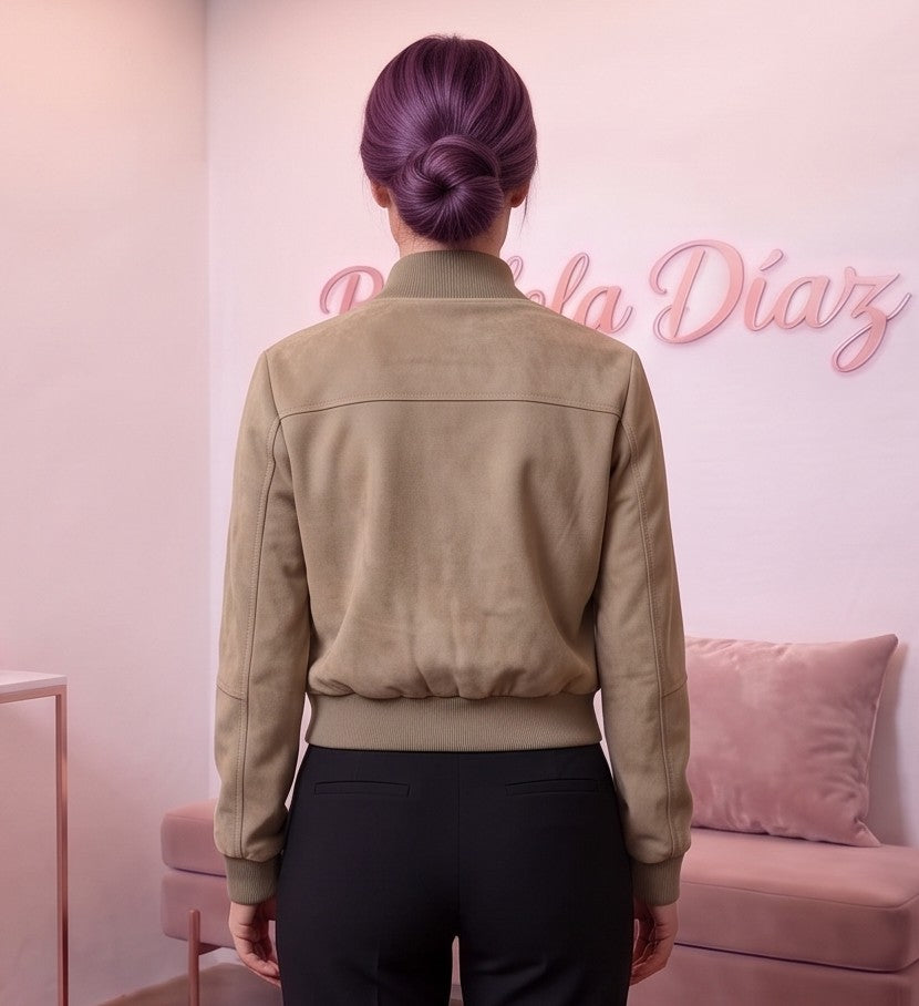 Chaqueta corta estilo bomber para mujer con cuello alto elástico acanalado, cremallera metálica central, dos bolsillos con solapa en el pecho y bolsillos laterales de cremallera, confeccionada en tejido de efecto antelina suave disponible en tonos caqui y gris oscuro