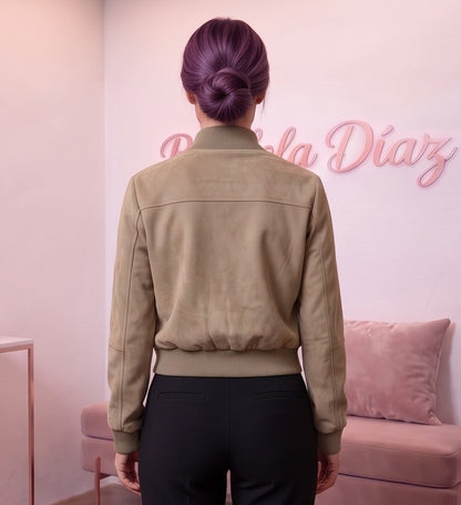 Chaqueta corta estilo bomber para mujer con cuello alto elástico acanalado, cremallera metálica central, dos bolsillos con solapa en el pecho y bolsillos laterales de cremallera, confeccionada en tejido de efecto antelina suave disponible en tonos caqui y gris oscuro