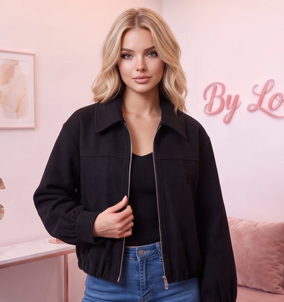 Cazadora estilo bomber de corte holgado para mujer en paño tipo lana suave, disponible en marrón caqui oscuro y negro, con cuello camisero de solapa, cierre frontal de cremallera metálica, puños ajustados y bajo elástico fruncido
