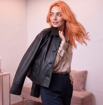 Chaqueta corta tipo cazadora para mujer en piel sintética efecto cuero con cuello camisero de solapa, cierre frontal abotonado, bolsillos diagonales ribeteados y corte recto relajado, disponible en color negro clásico y tono marrón caramelo teja sobre fondo de estudio elegante.