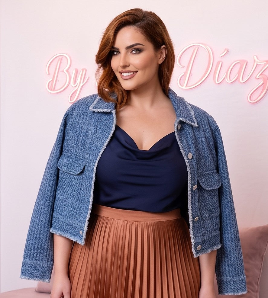 Chaqueta corta de mujer en tejido texturizado azul denim con bolsillos frontales de parche, cuello clásico y botones blancos estilo joya, ideal para un look casual y urbano.