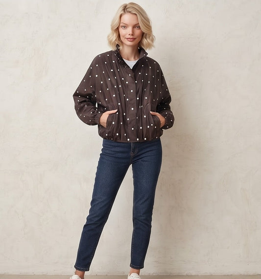 Chaqueta cortavientos de mujer con estampado de lunares, cuello alzado y cierre de cremallera, ideal para un look casual y urbano.