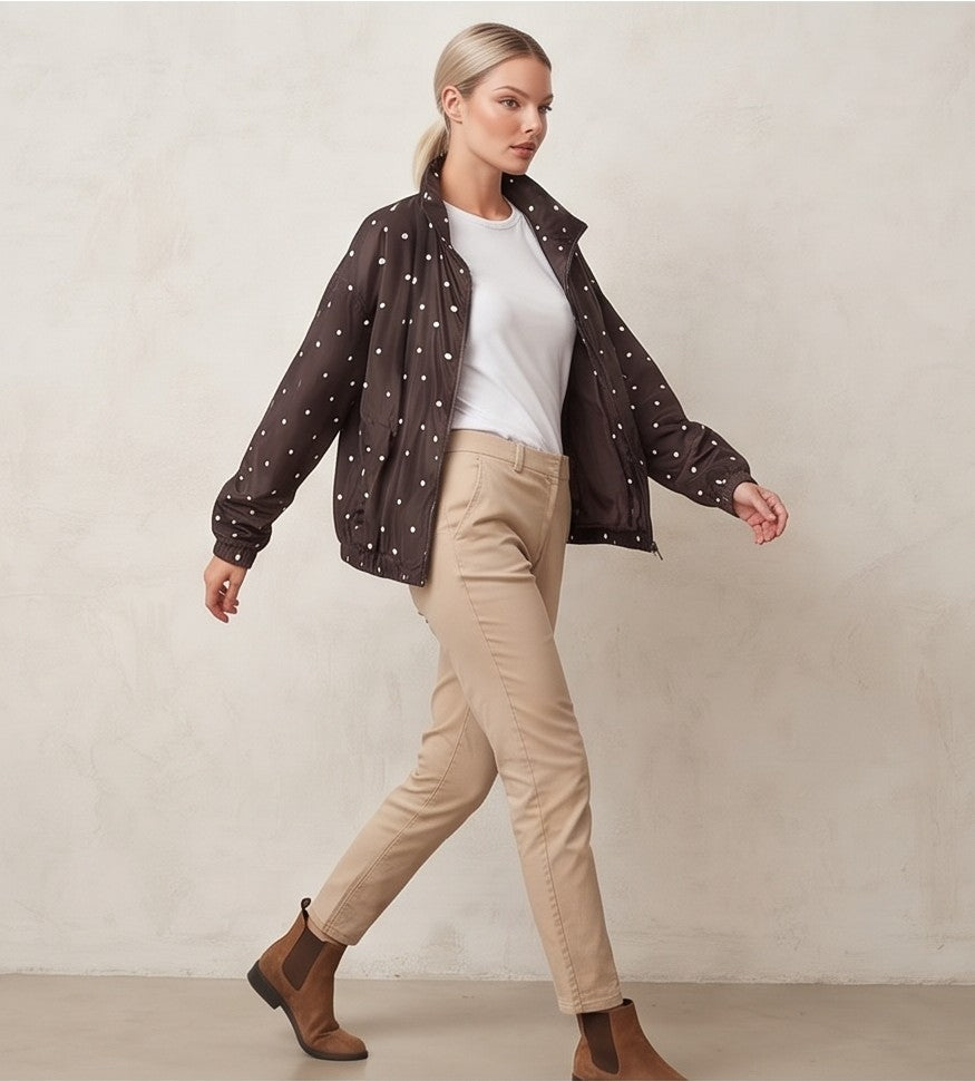 Chaqueta cortavientos de mujer con estampado de lunares, cuello alzado y cierre de cremallera, ideal para un look casual y urbano.