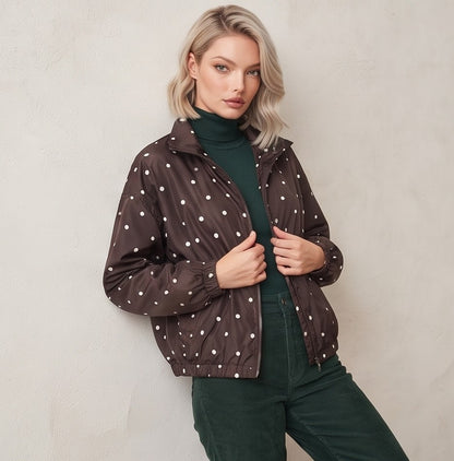 Chaqueta cortavientos de mujer con estampado de lunares, cuello alzado y cierre de cremallera, ideal para un look casual y urbano.