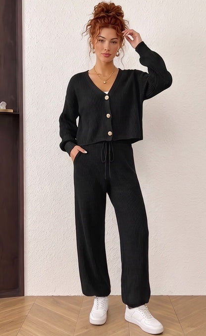Conjunto de dos piezas de punto acanalado para mujer compuesto por cárdigan de manga larga con cuello en pico y botones frontales, a juego con pantalón largo holgado de tiro alto y cintura elástica con cordón ajustable; disponible en color azul cielo, crema albaricoque y negro.