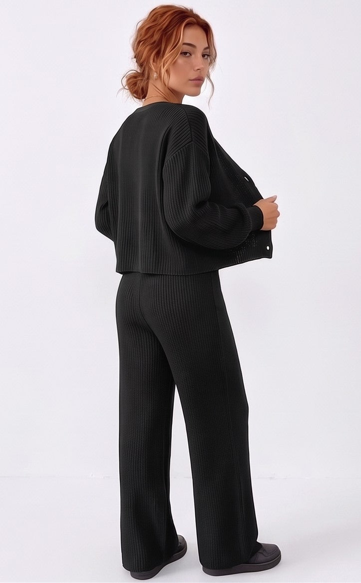 Conjunto de dos piezas de punto acanalado para mujer compuesto por cárdigan de manga larga con cuello en pico y botones frontales, a juego con pantalón largo holgado de tiro alto y cintura elástica con cordón ajustable; disponible en color azul cielo, crema albaricoque y negro.