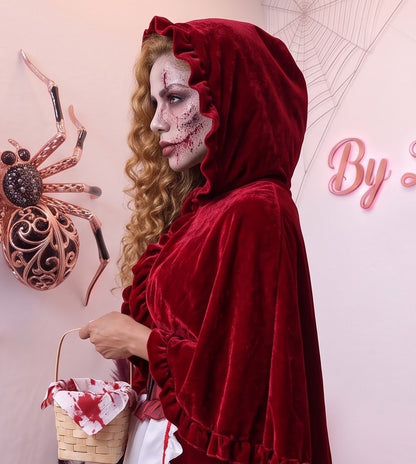 Disfraz de Caperucita Roja estilo gótico y fantasía para mujer, compuesto por vestido de terciopelo rojo vino con corpiño a rayas, delantal blanco con volantes, falda acampanada con ribete blanco y capa corta a juego con capucha amplia con fruncidos.