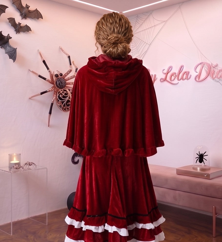 Disfraz de Caperucita Roja estilo gótico y fantasía para mujer, compuesto por vestido de terciopelo rojo vino con corpiño a rayas, delantal blanco con volantes, falda acampanada con ribete blanco y capa corta a juego con capucha amplia con fruncidos.