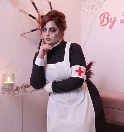 Disfraz vintage de enfermera de época victoriana o monja médica para mujer, compuesto por vestido largo negro de cuello alto y manga larga con puños blancos, delantal blanco con tirantes cruzados a la espalda, brazalete blanco con cruz roja y cofia blanca fruncida a juego