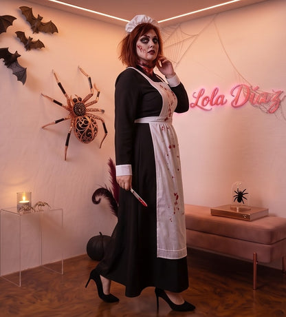 Disfraz vintage de enfermera de época victoriana o monja médica para mujer, compuesto por vestido largo negro de cuello alto y manga larga con puños blancos, delantal blanco con tirantes cruzados a la espalda, brazalete blanco con cruz roja y cofia blanca fruncida a juego
