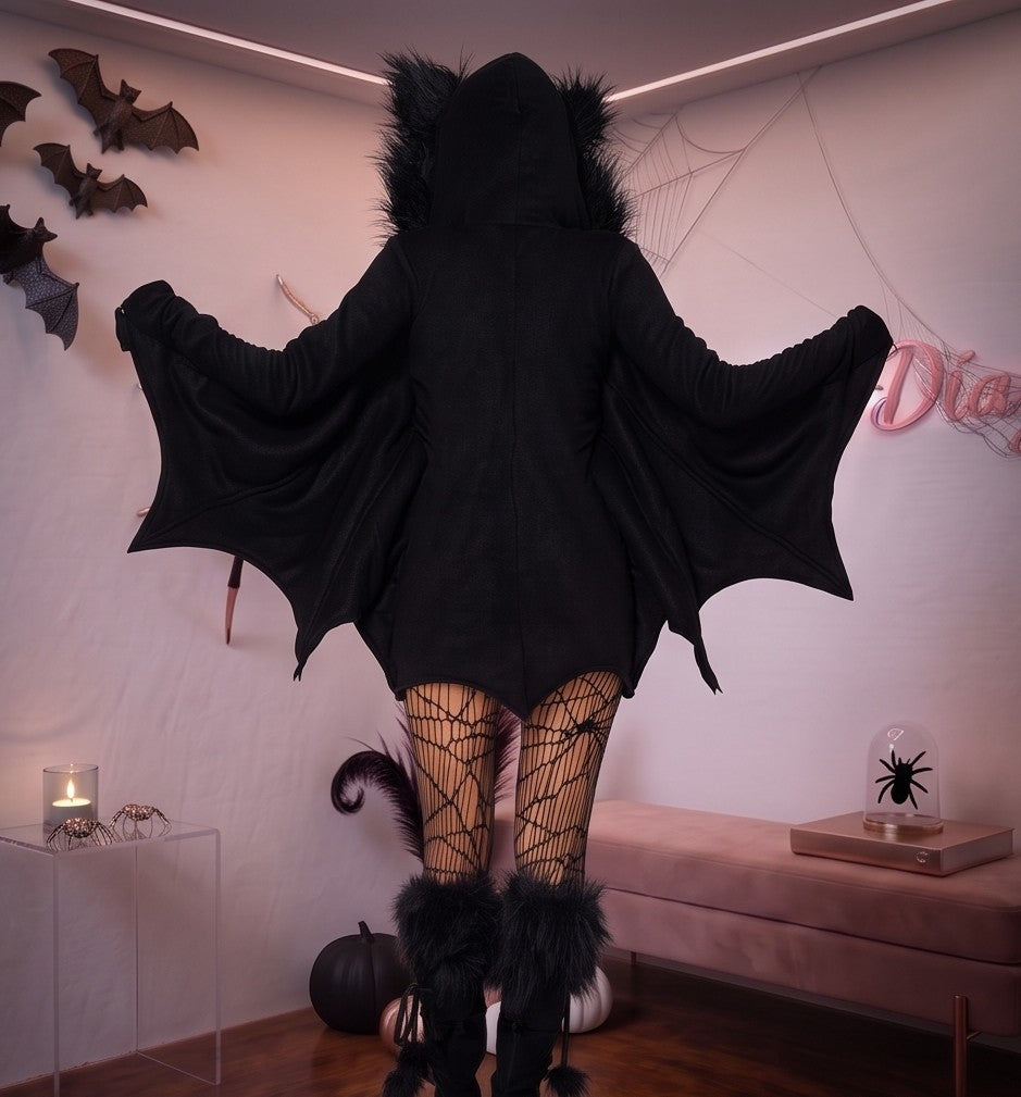 Disfraz enterizo de murciélago para mujer en tejido negro suave tipo pana con cremallera frontal, mangas murciélago que simulan alas extendidas y capucha afelpada con orejas puntiagudas.