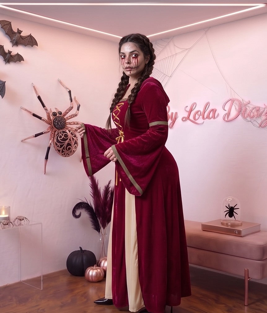 Disfraz medieval y gótico de mujer con vestido largo hasta los pies en tejido de terciopelo rojo burdeos, detalle frontal drapeado en tono crema y corsé con lazos dorados cruzados, mangas largas acampanadas acampanadas con ribetes dorados y capucha holgada integrada, ideal para caracterización teatral, temática de época y Halloween.