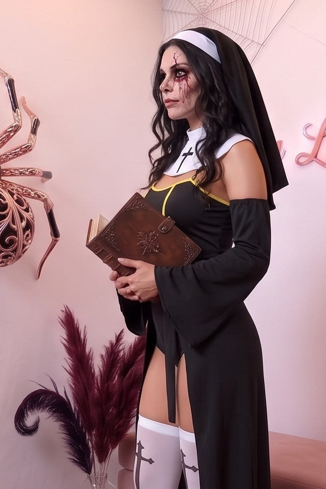 Disfraz cosplay de monja gótica en mezcla de algodón negro, compuesto por enterizo con detalles amarillos, sobrefalda abierta en cintura, mangas acampanadas desmontables, cuello blanco con cruz, velo y medias altas blancas con cruz estampada.